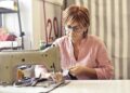 mujer aprendiendo a usar una máquina de coser para principiantes en un taller de costura luminoso