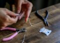 Materiales y herramientas para hacer broches artesanales en una mesa de joyería hecha a mano