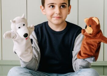 Niño jugando con marionetas de calcetín de colores