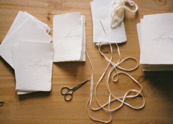 Mesa de trabajo de scrapbooking con papeles, tijeras y materiales de corte