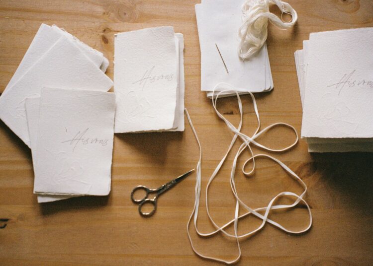 Mesa de trabajo de scrapbooking con papeles, tijeras y materiales de corte