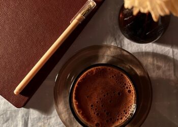 Cuaderno de bullet journal abierto sobre una mesa con café, listo para organizar la semana