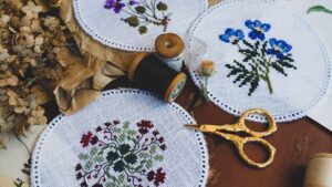 Madejas de hilo de bordar de colores y tijeras sobre la mesa de trabajo