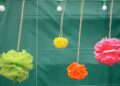 Pompones de papel de seda de colores colgados como decoración de fiesta