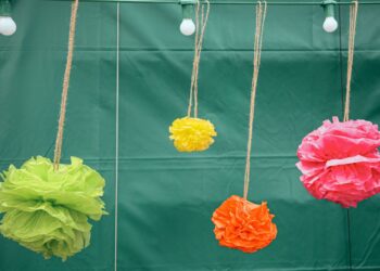 Pompones de papel de seda de colores colgados como decoración de fiesta