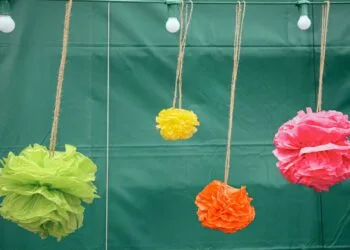 Pompones de papel de seda de colores colgados como decoración de fiesta