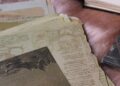 Materiales de embossing en caliente: sellos, papeles vintage y polvos sobre la mesa de trabajo