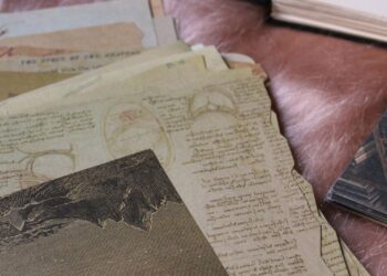 Materiales de embossing en caliente: sellos, papeles vintage y polvos sobre la mesa de trabajo