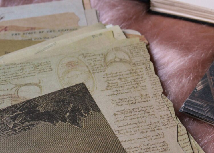 Materiales de embossing en caliente: sellos, papeles vintage y polvos sobre la mesa de trabajo