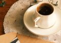 Cartas de papel envejecido junto a una taza de café sobre madera, técnica para envejecer papel