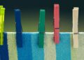 Pinzas de madera de colores sobre tela a rayas para manualidades con pinzas de madera