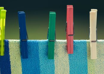 Pinzas de madera de colores sobre tela a rayas para manualidades con pinzas de madera