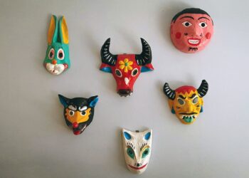 Máscara artesanal de papel maché colgada en una pared, ejemplo de pieza terminada