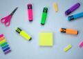 Material escolar y de manualidades vuelta al cole sobre fondo azul con tijeras y rotuladores