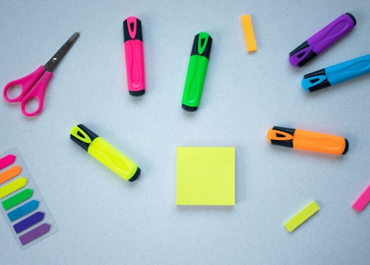 Material escolar y de manualidades vuelta al cole sobre fondo azul con tijeras y rotuladores