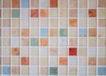 Teselas de cerámica de colores colocadas sobre una superficie para hacer un mosaico paso a paso