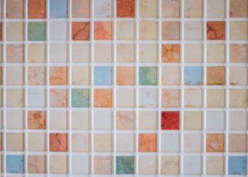 Teselas de cerámica de colores colocadas sobre una superficie para hacer un mosaico paso a paso