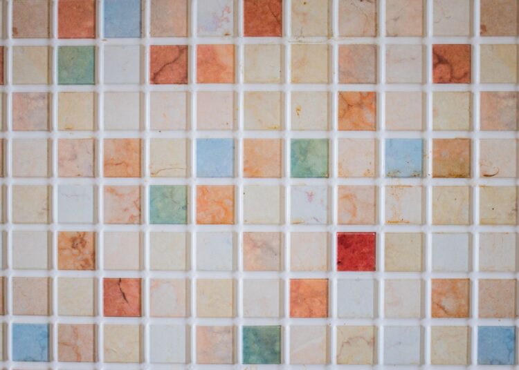 Teselas de cerámica de colores colocadas sobre una superficie para hacer un mosaico paso a paso
