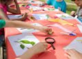 Niños creando con materiales de kits de manualidades para niños sobre una mesa de trabajo