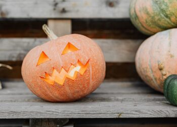Calabazas iluminadas y farolillos en un banco de madera como decoración de Halloween casera