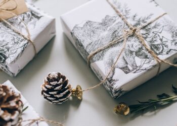 Materiales de scrapbooking de Navidad sobre una mesa: papeles estampados, cordel y adornos