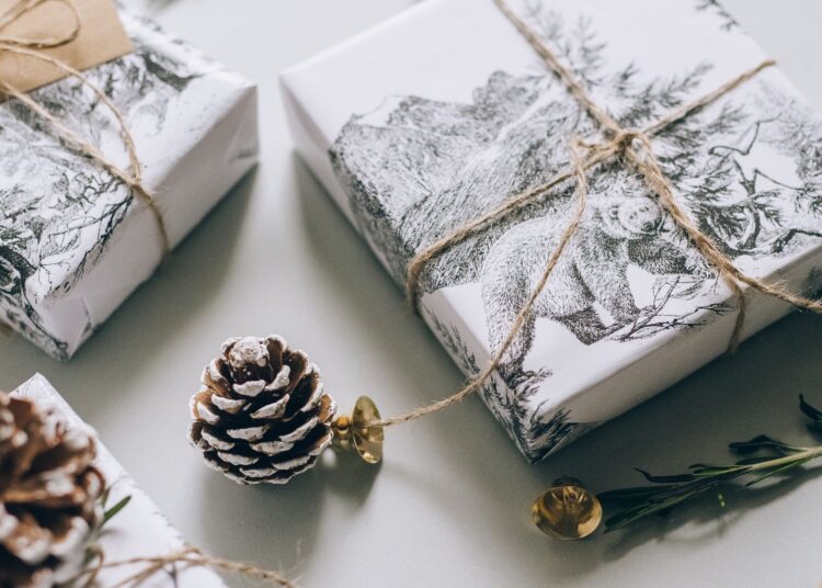 Materiales de scrapbooking de Navidad sobre una mesa: papeles estampados, cordel y adornos