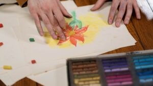 Persona dibujando una flor a lápiz en un cuaderno, ejemplo de cómo dibujar flores paso a paso