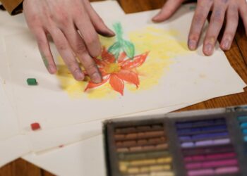 Persona dibujando una flor a lápiz en un cuaderno, ejemplo de cómo dibujar flores paso a paso